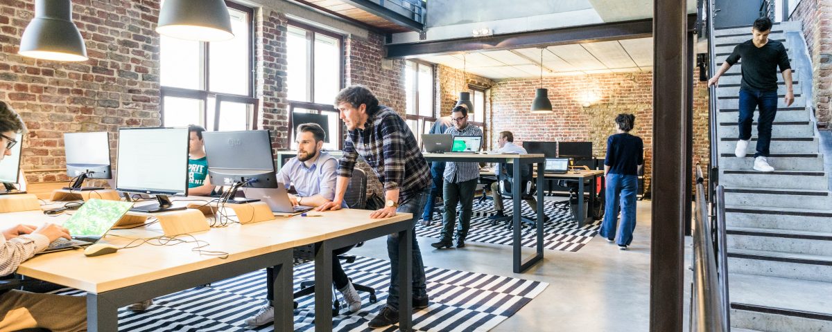 Oficina de una startup con empleados trabajando en un espacio colaborativo moderno